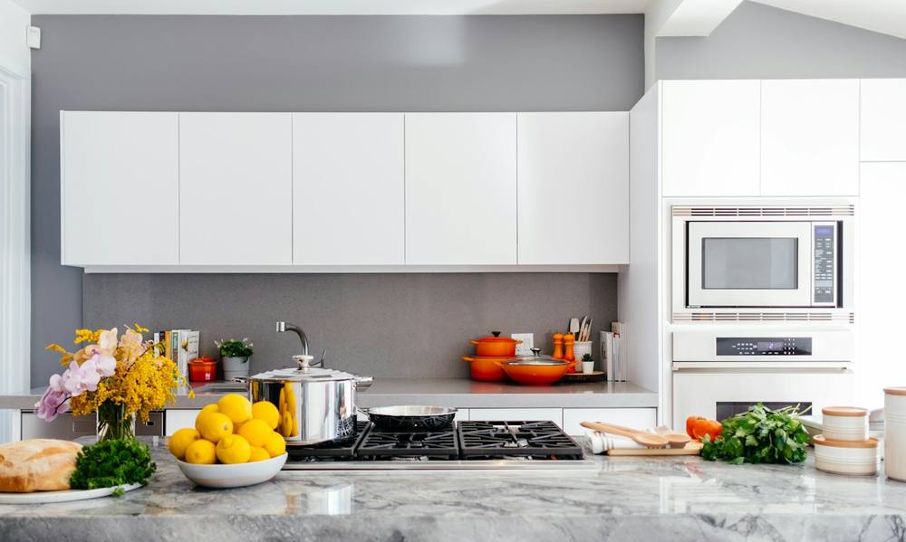 Bright, spotless modern kitchen with clean white cabinets and polished counters